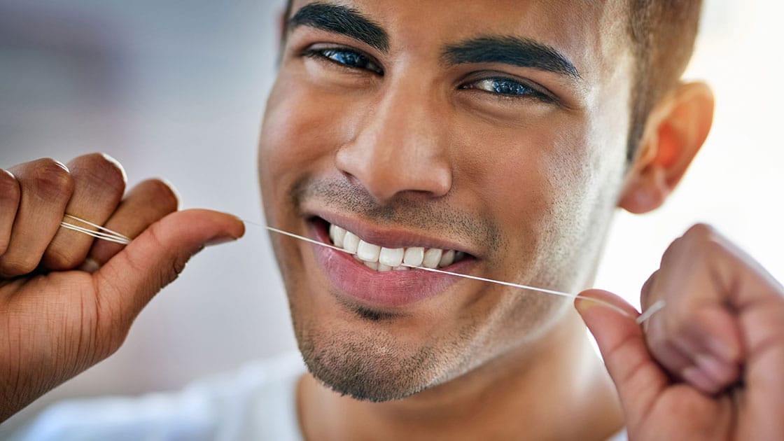 Man flossing his teeth